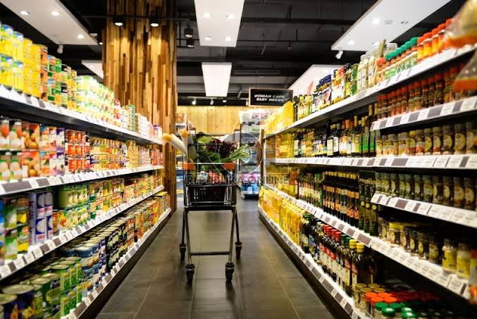 Pemilik toko retail menata produk secara rapi berdasarkan kategori di rak toko